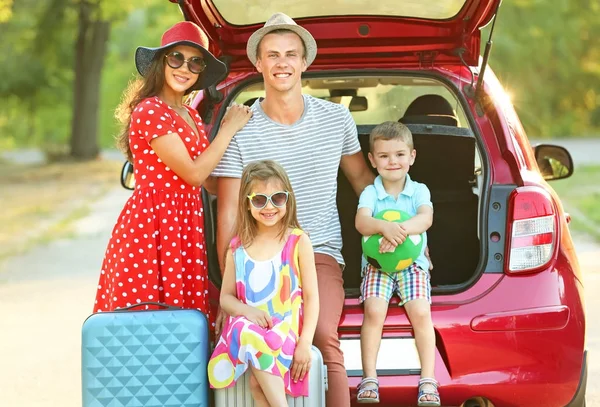 Happy family next to car in countryside — Stock Photo, Image