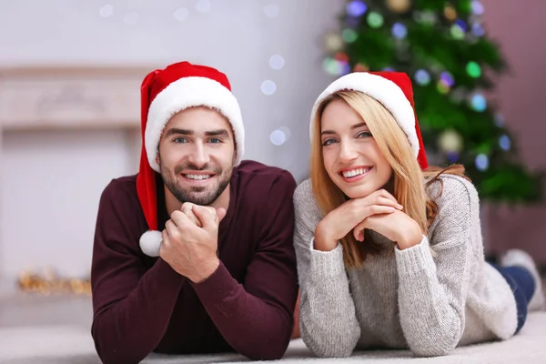 Junges Paar in Weihnachtsmannhüten — Stockfoto