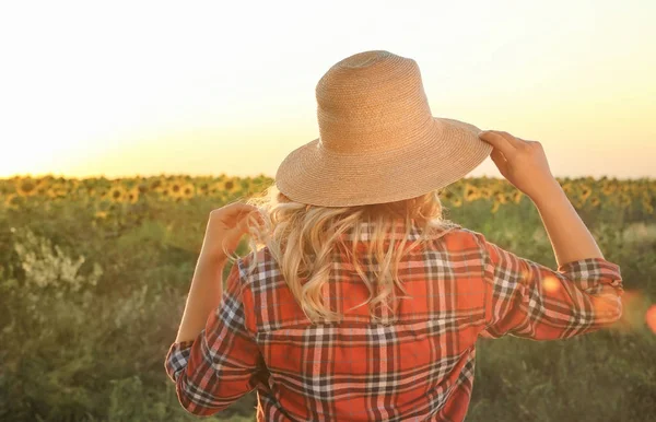 Jovem mulher de chapéu de vime perto do campo de girassol — Fotografia de Stock