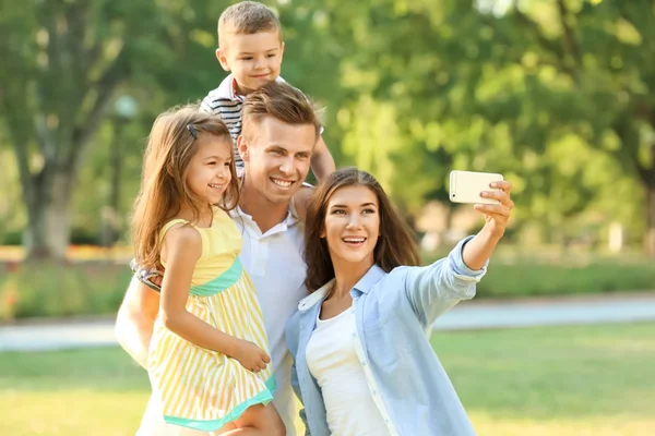 Família feliz fazendo selfie no parque — Fotografia de Stock