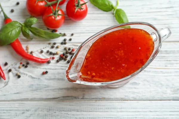 Samenstelling met chili saus in jus boot — Stockfoto