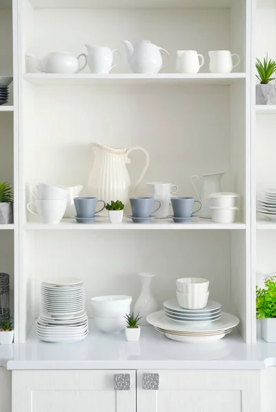 White storage stand with ceramic dishware in kitchen — Stock Photo, Image