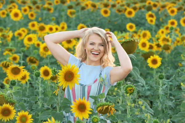 Blonde Frau im Sonnenblumenfeld — Stockfoto