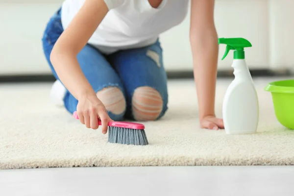 Frau putzt Teppich mit Bürste — Stockfoto