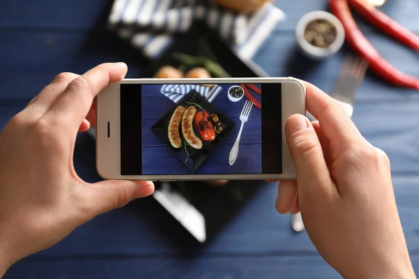 Narablog perempuan mengambil foto makanan dengan smartphone di dalam ruangan — Stok Foto