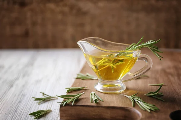 Biberiye yağı ve ahşap tahta üzerinde bitki ile et suyu tekne