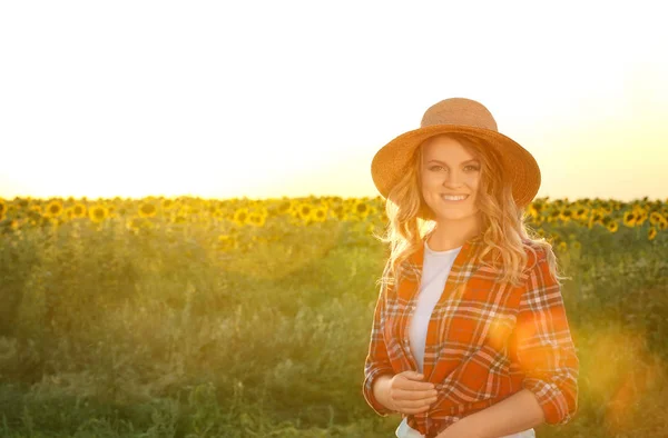 Ayçiçeği field yakınındaki hasır şapkalı genç kadın — Stok fotoğraf