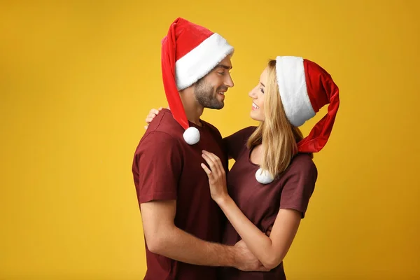 Jeune couple dans chapeaux de Père Noël — Photo