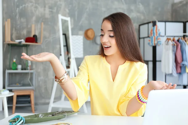 Young female blogger with stylish accessories at home