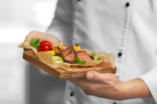 Chef com prato de carne saborosa — Fotografia de Stock