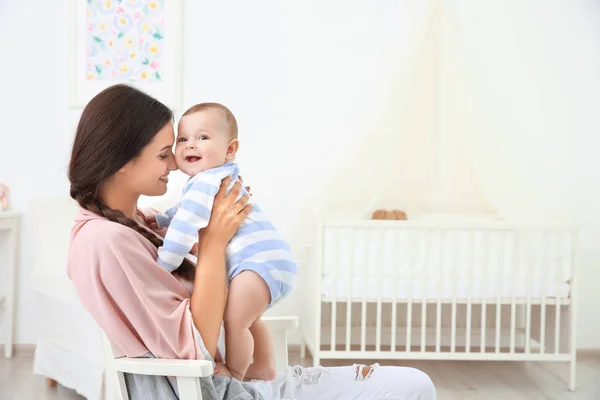 Mother and cute baby sitting on chair after bathing at home — Stock Photo, Image