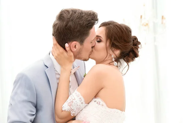 Feliz lindo casal beijando no dia do casamento, dentro de casa — Fotografia de Stock