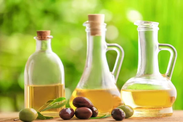 Friska oliver och flaskor olja — Stockfoto