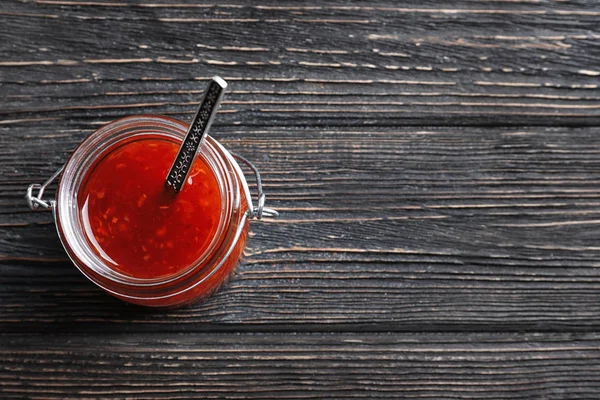 Sauce chili au bocal sur table en bois — Photo