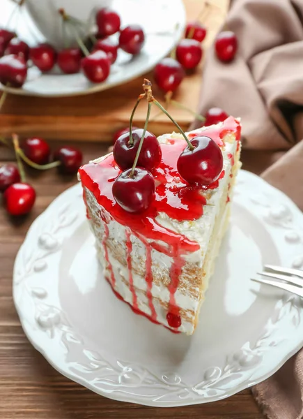 Plate with piece of delicious cherry cake on table — Stock Photo, Image