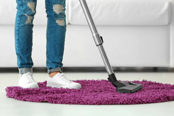 Mujer limpieza pequeña alfombra con vacío — Foto de Stock