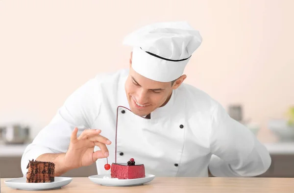 Молодий чоловічий шеф-кухар, який прикрашає смачний десерт на кухні — стокове фото