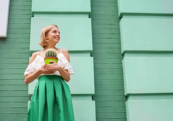 Jeune femme hipster heureux en jupe verte tenant cactus à l'extérieur — Photo