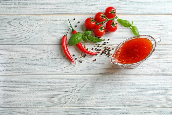 Composition with chili sauce in gravy boat — Stock Photo, Image