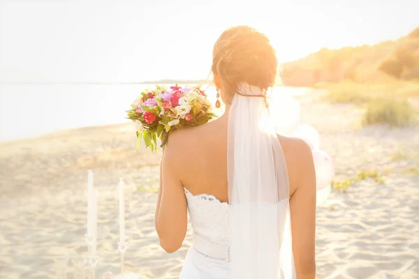 Hermosa novia con ramo de bodas en la playa — Foto de Stock