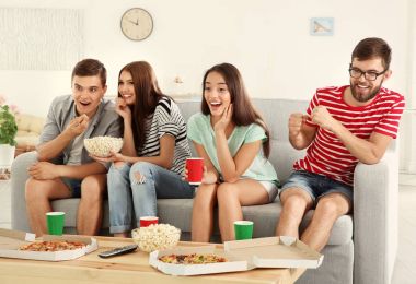 Arkadaşlar evde televizyon izliyor.
