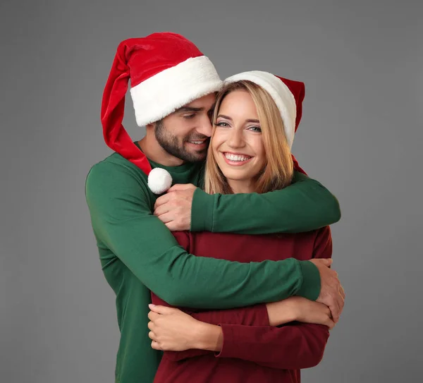 Jeune couple dans chapeaux de Père Noël — Photo