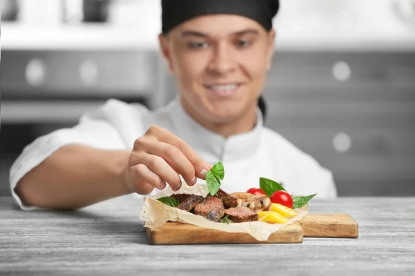 Chef decoração saborosa carne suculenta na mesa — Fotografia de Stock