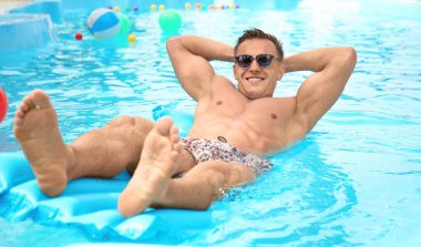 Çekici bir adam şişme şişme yüzme havuzunda