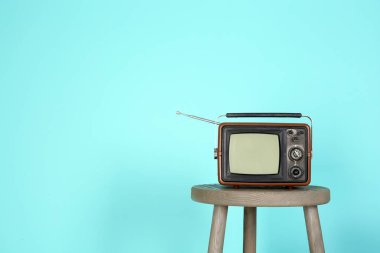 Vintage dışkı rengi duvarının yakınında televizyonda