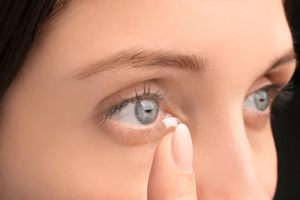 Young woman putting contact lens — Stock Photo, Image