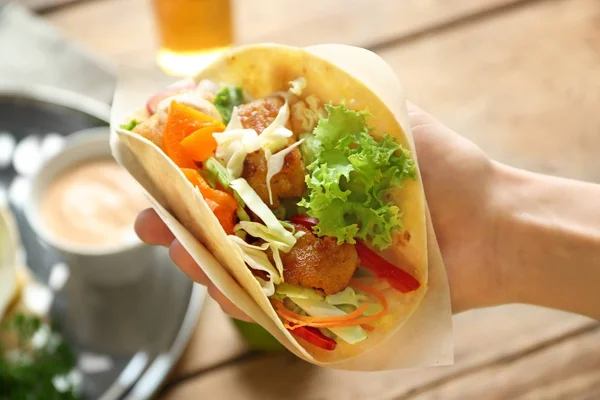 Hand holding delicious fish taco