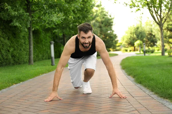 Hombre deportivo guapo en posición inicial para correr al aire libre — Foto de Stock