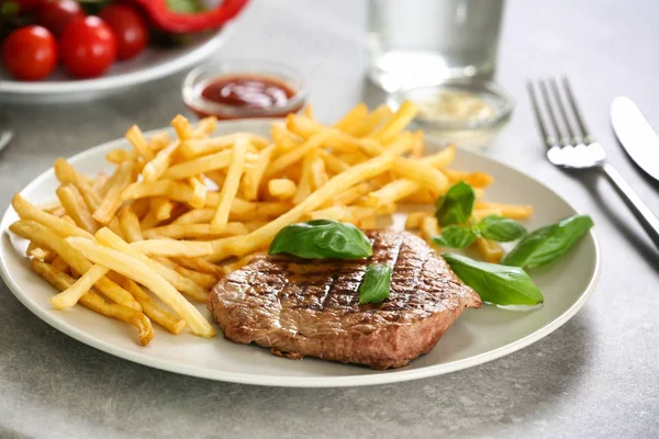 Prato com delicioso bife e batatas fritas — Fotografia de Stock