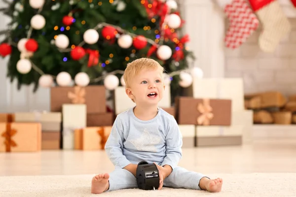 Niedliches kleines Baby mit Uhr zu Hause. Weihnachts-Countdown-Konzept — Stockfoto