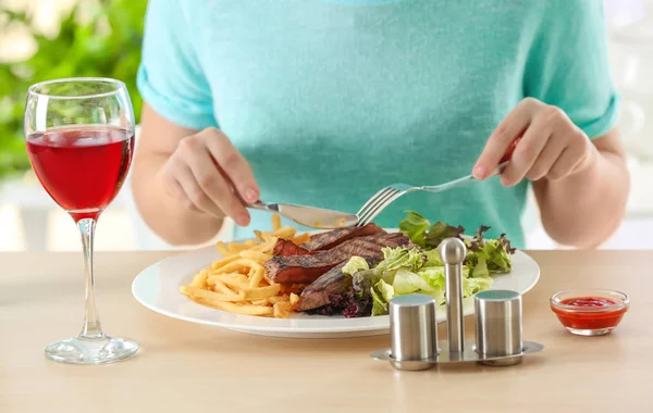 Woman eating delicious grilled steak — Stock Photo, Image