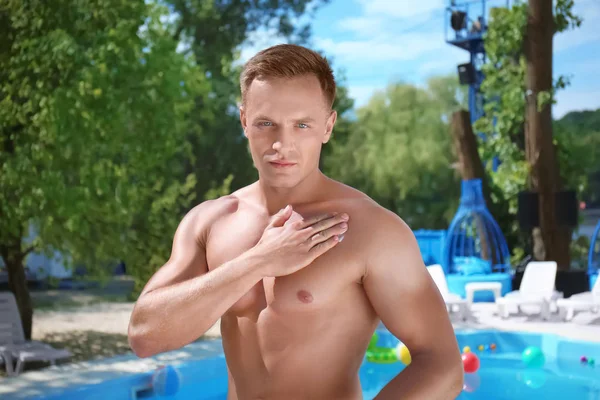 Çekici bir adam güneş koruyucu deri Yüzme Havuzu yakınındaki üzerine uygulama