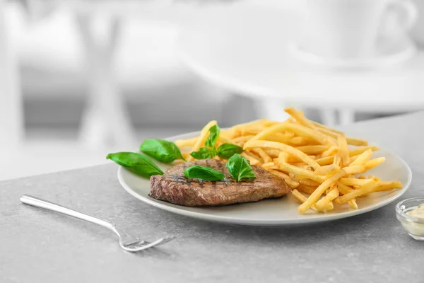 Тарелка с вкусным стейком и картошкой фри — стоковое фото