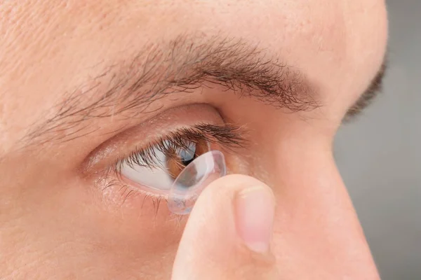 Joven poniendo lentes de contacto en su ojo — Foto de Stock