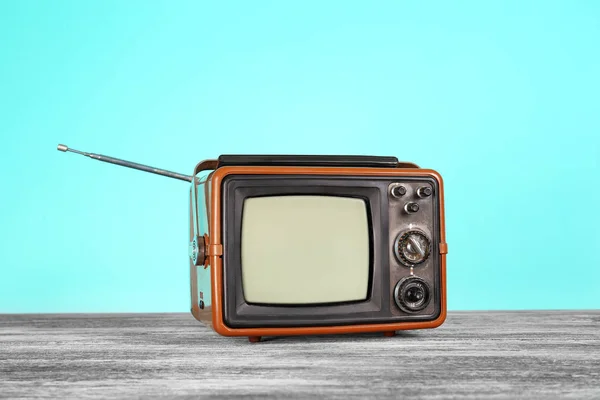 Vintage televisie op houten tafel in de buurt van kleur muur — Stockfoto