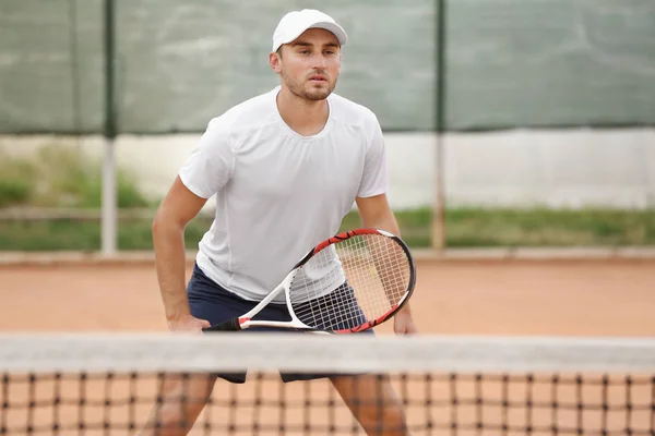 Mladý muž hrát tenis na kurtech — Stock fotografie