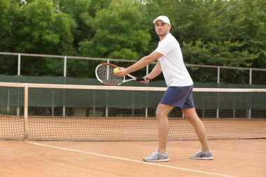 kortta Tenis oynayan genç adam