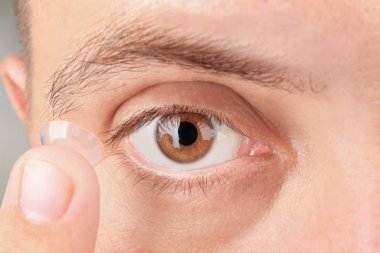 Onun gözünde koyarak Kontakt lens genç adam