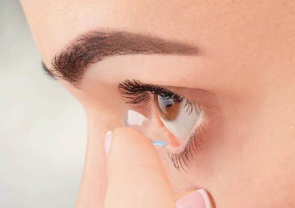 Jonge vrouw zetten contactlenzen — Stockfoto