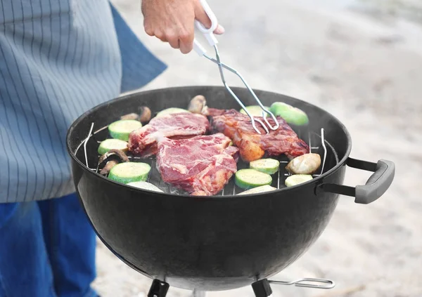 Man koken smakelijke steaks en groenten — Stockfoto