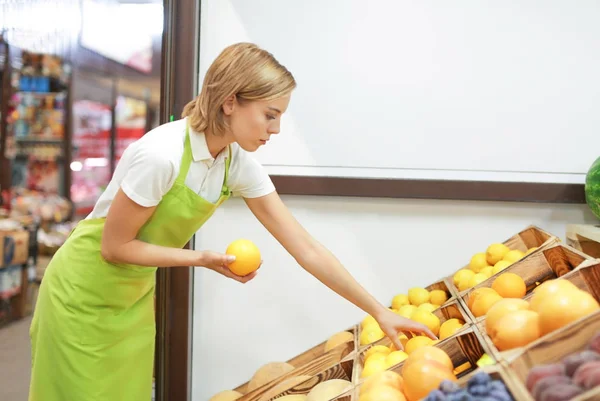 Arbeiter legt Früchte auf dem Markt aus — Stockfoto