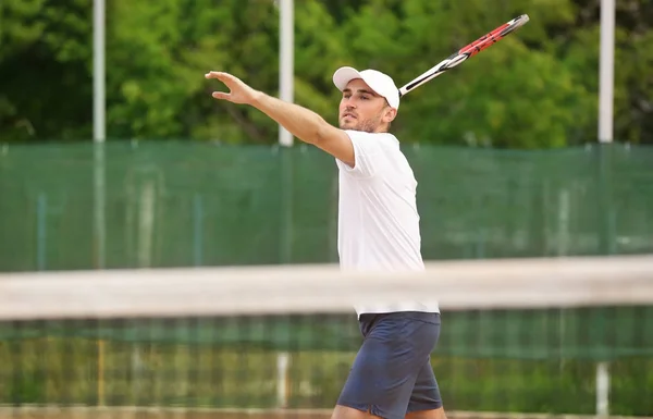 Joven jugando al tenis en la cancha — Foto de Stock