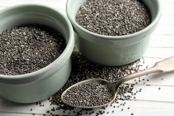 Chia seeds in bowls and spoon on table — Stock Photo, Image