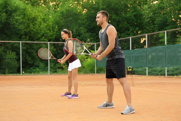 Jonge man en vrouw tennissen op Hof — Stockfoto