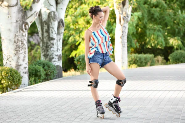 Jonge vrouw rolschaatsen in park — Stockfoto