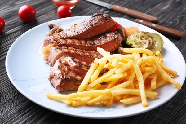 Teller mit leckerem Steak und Garnitur — Stockfoto